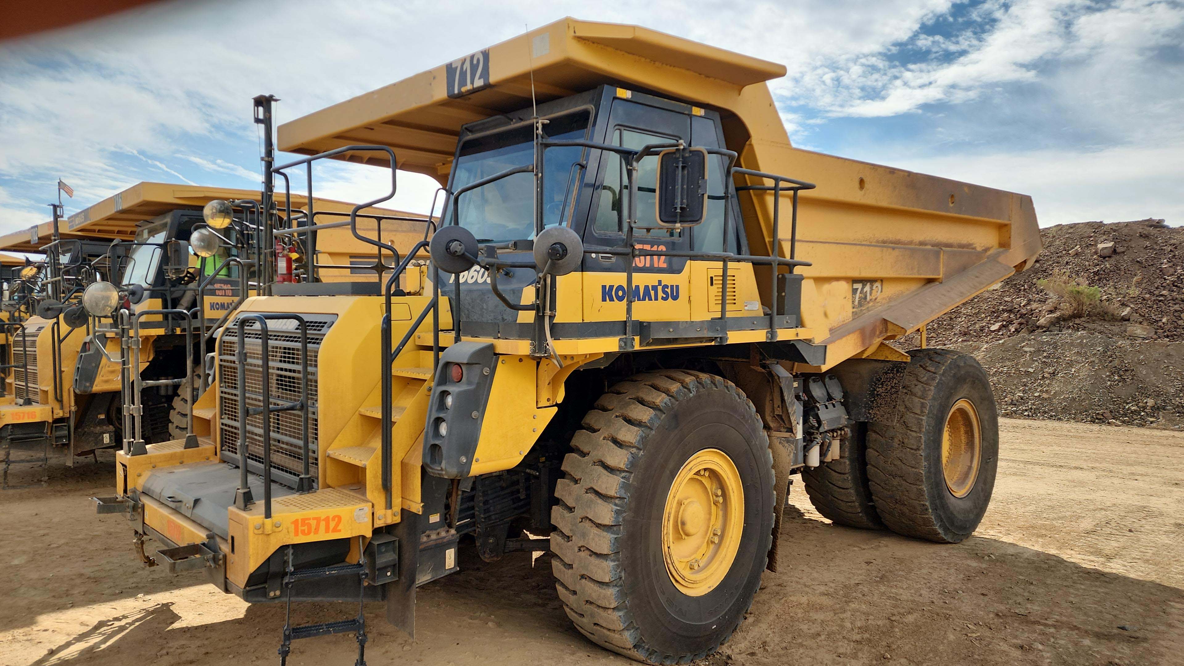 Yellow front loader moving rocks at a quarry.