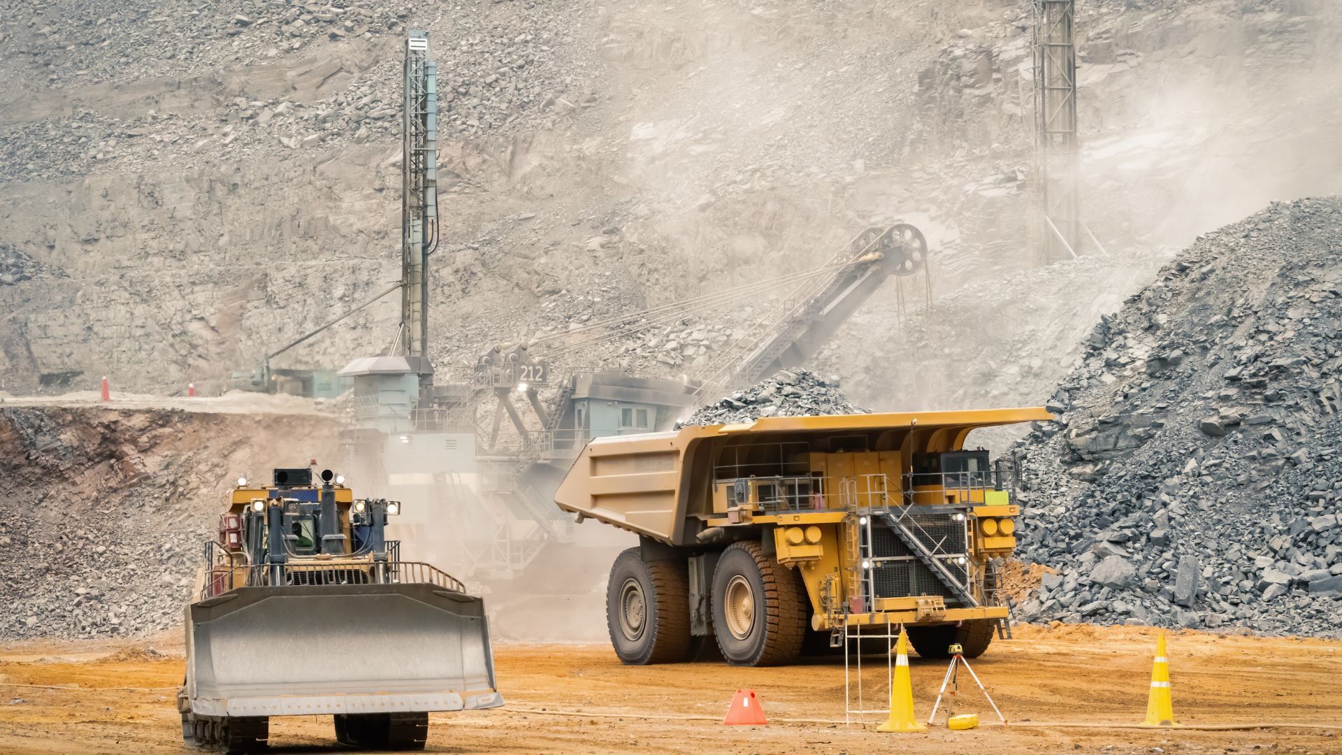 Yellow front loader moving rocks at a quarry.